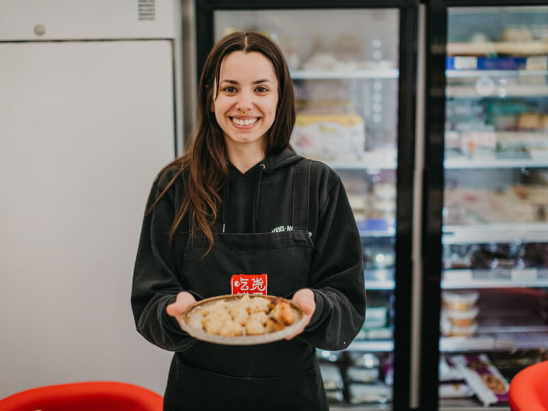woman smiling with plate of homemade dumplings